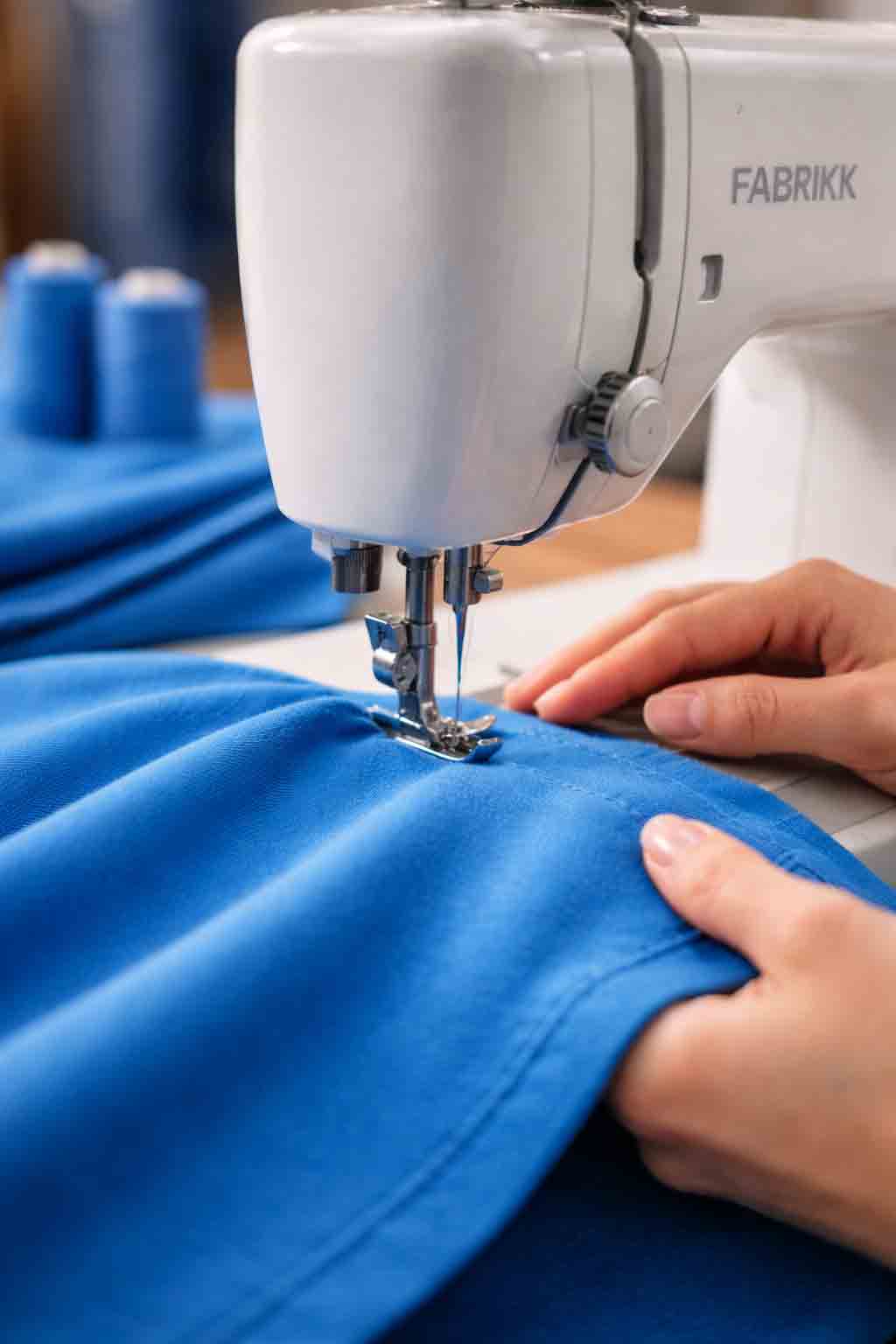 Portrait close-up of sewing machine stitching blue fabric